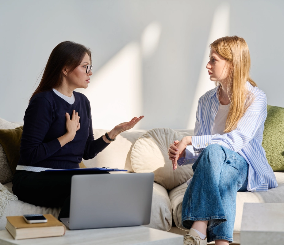 Two women having a serious discussion indoors.