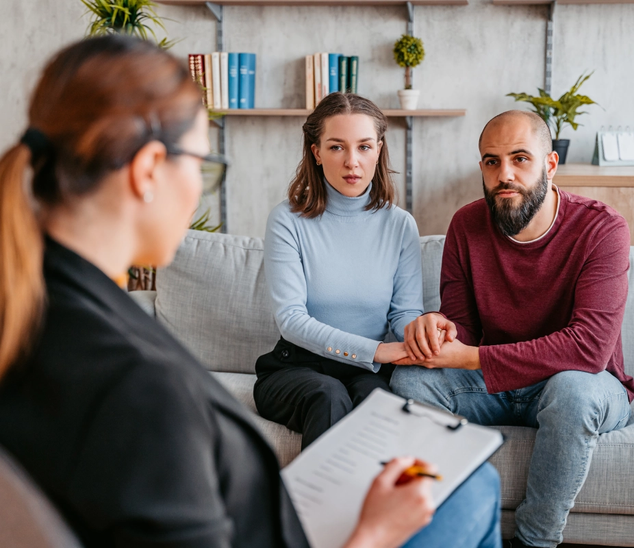 Couple in therapy session with counselor.