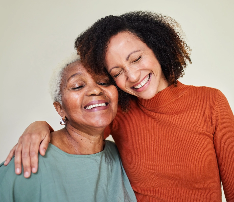 Smiling women embracing, showing joyful connection.