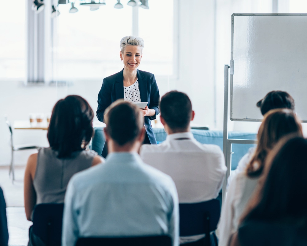Woman presenting to a group in office.