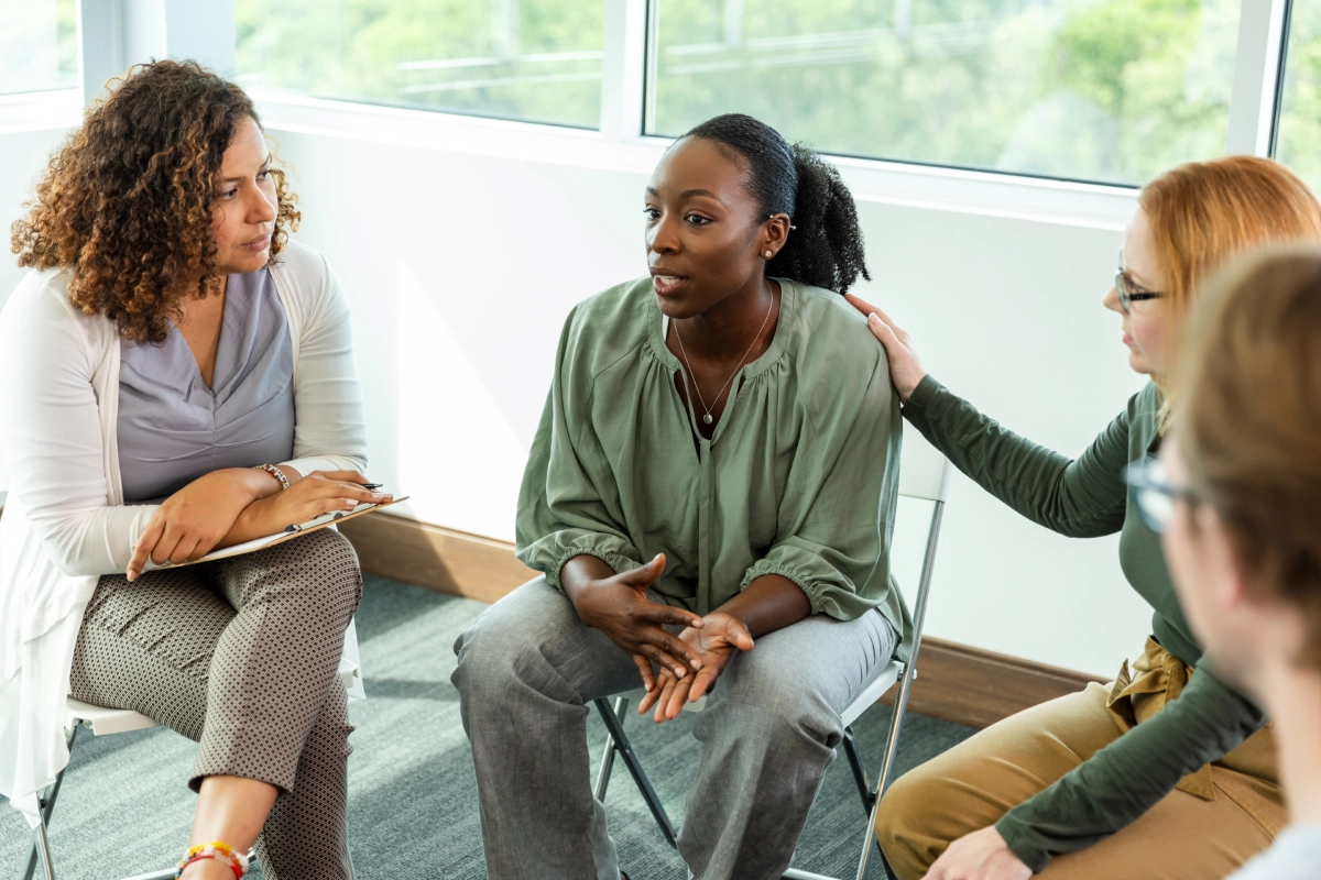 Supportive group discussion in bright meeting room.