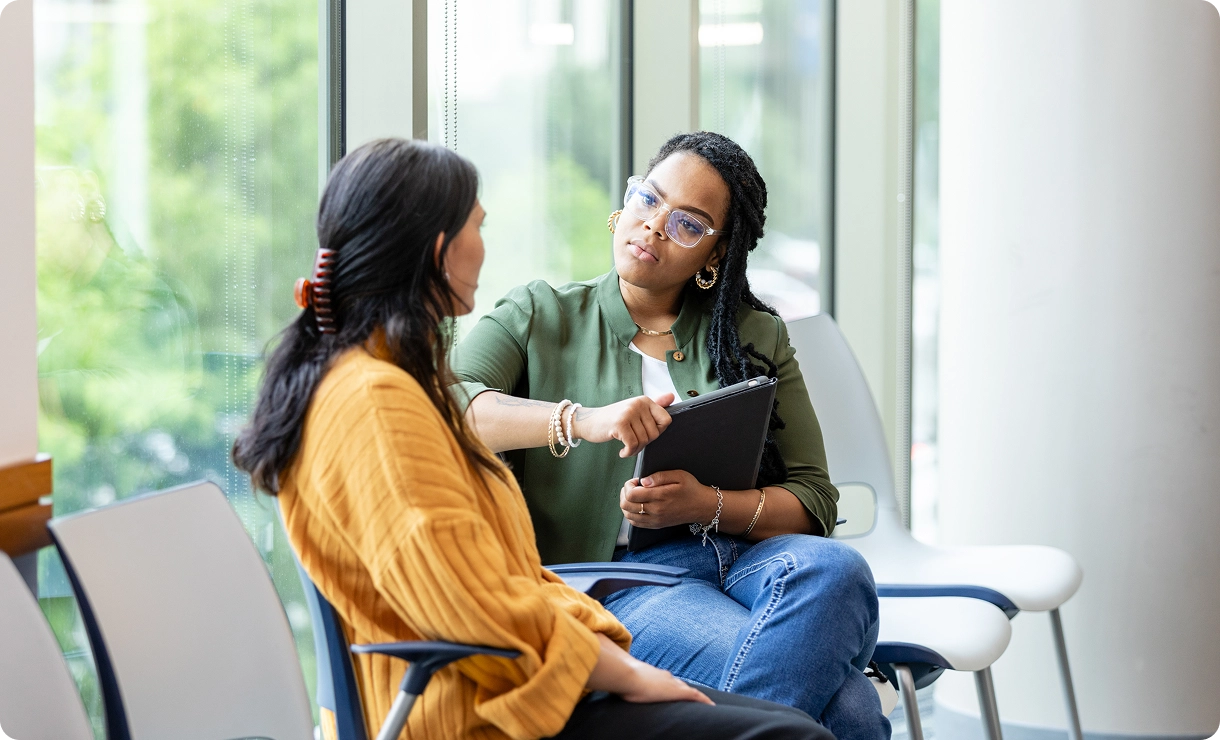 Two women having a serious conversation indoors.