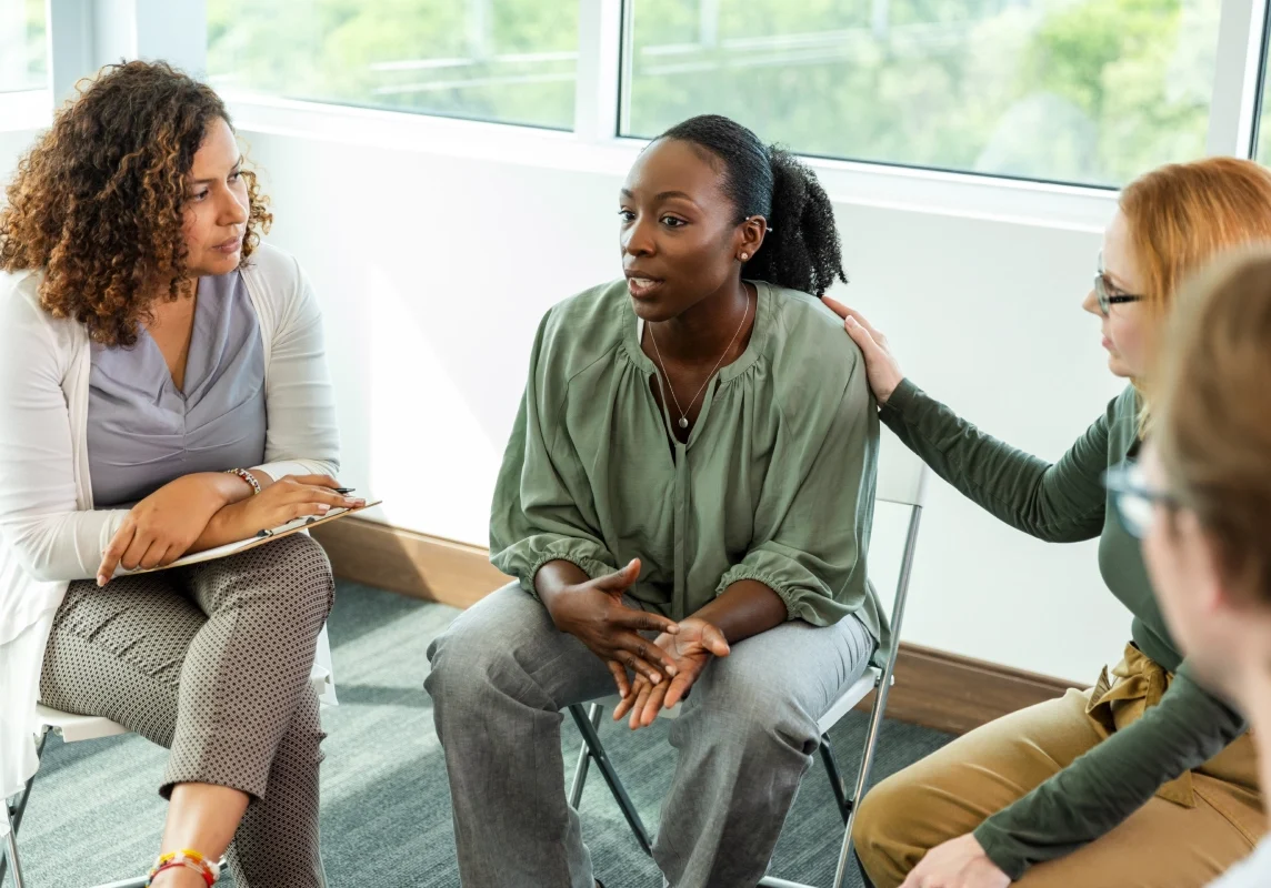 Supportive group discussion in bright meeting room.